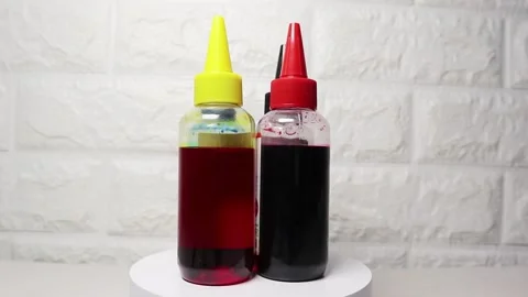 Transparent printer ink bottle rotating on a white surface, highlighting it.. Stock Footage 297151548