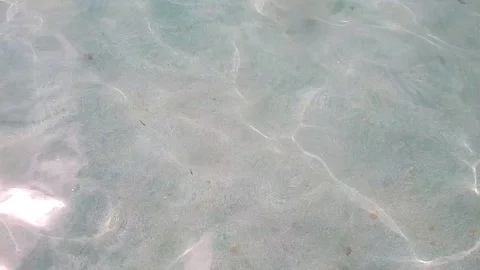 Transparent sea with reflections on surface and white sand on the sea bottom. Stock Footage 77138150