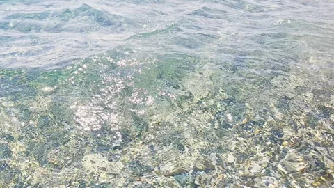 Transparent sea with sunlit waves and green-tinted water viewed from low an.. 库存影片 340926394