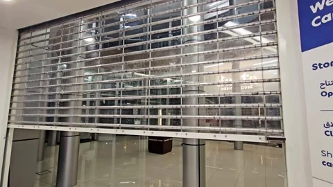 A transparent security rolling shutter door opens slowly up, revealing a modern Stock-Footage 341702873