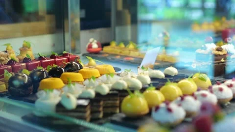 Transparent showcase with different types and tastes of cake. A hand in a Video stock 217415656