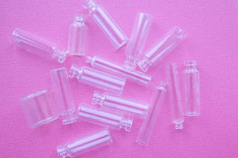 Transparent small bubbles on pink background. Glass jars Stock Photos