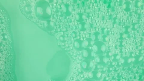 Transparent soap bubbles on green turquoise background. Soapy bubbles and Video stock 296505393