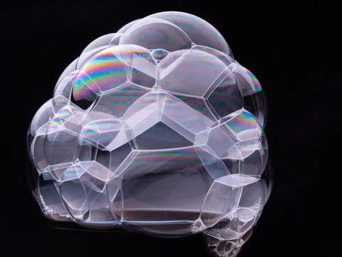Transparent soap bubbles isolated on black background. Rainbow gradient and Stock Photos