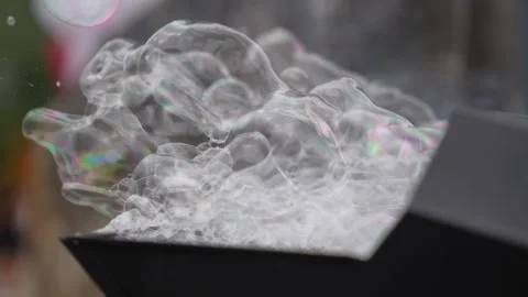 Transparent soap bubbles stack near a foam outlet as thin films catch light.. Stock Footage 324896239