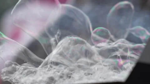 Transparent soap bubbles stack near a foam outlet as thin films catch light.. Stock Footage 324896305