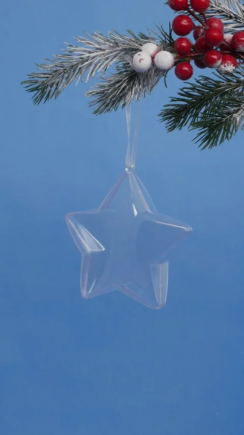 Transparent star-shaped Christmas tree toy hanging on a New Year's tree bra.. Stock Footage 312928438