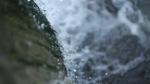 Transparent stream water drops fall from brown cliff macro Stock Footage 143358661