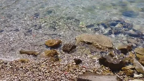 Transparent surf waves on a stone shore on a sunny summer day Stock Footage 201778960