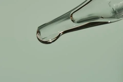 Transparent texture of a drop of serum on a light green background. Transparent Fotos de archivo