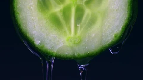 Transparent water drop flowing down from bright green cucumber slice Stock Footage 270478281