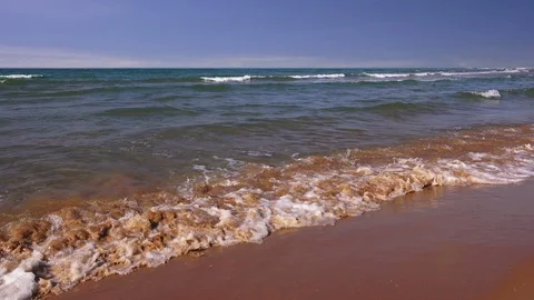 Transparent waves roll on a sandy beach Video stock 93426284