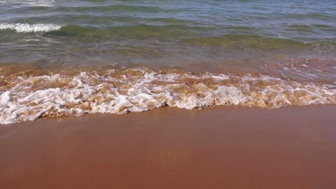 Transparent waves roll on a sandy beach,  sunny day, closeup view Video stock 98844573