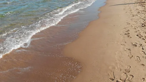 Transparent waves roll on a sandy beach Stock Footage 98888951