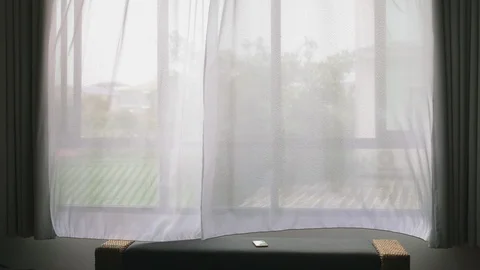 Transparent window curtain, gently moved by the wind. outside the window you can Stock Footage 99413358