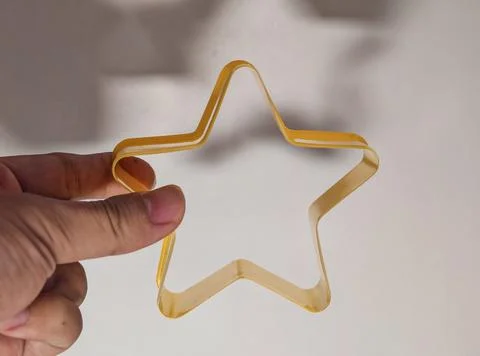 Transparent Yellow Star Shape Held by Hand Representing Creativity and Imagi Foto stock