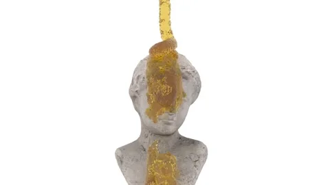 A transparent yellow substance falls on the head of an ancient statue and drips Stock Footage 156043685