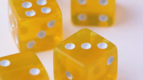 Transparent Yellow Worn Dice Spinning on a White Surface POV perspective Stock Footage 288704209