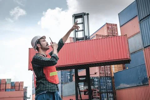 Transport Container Engineer Managing Control Via Walkie Talkie in Containers Stock Photos