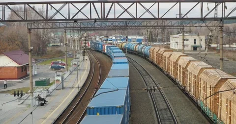 Transport. A freight train carrying containers passes through a railway station. Stock-Footage 289431492