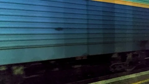 The transport train arrives at the station, at the platform stop at night Stock Footage 255607829