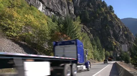 Transport truck flatbed entering tunnel, wide shot Stock Footage
