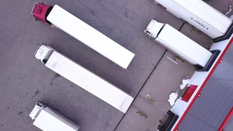 Transport Truck Reversing Into A Loading Dock. Aerial shot. Drone Stock Footage