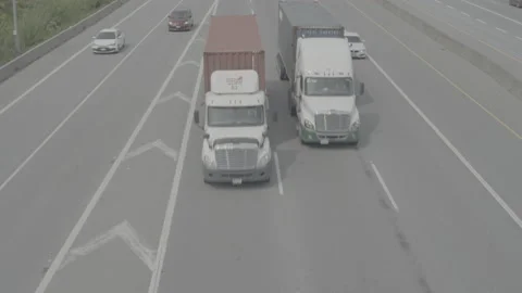 Transport trucks drive side by side along busy highway Video stock 199561407