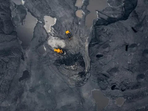 Transporting coal on yellow large dump truck. Open pit mine industry Top aerial Stock Photos