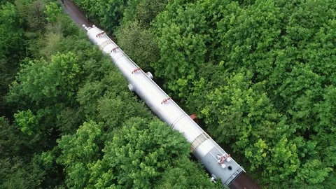Transporting a large pipe / reactor on a road through a forest on a summer day. Stock Footage 124244427