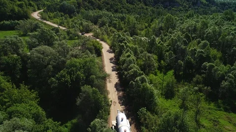 Transporting a large pipe / reactor on a road through a forest on a summer day. Stock Footage 124244820