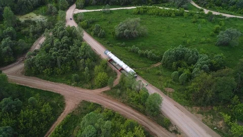 Transporting a large pipe / reactor on a road through a forest on a summer day. Stock Footage 124244858