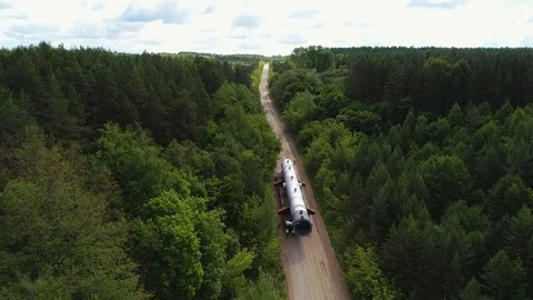 Transporting a large pipe / reactor on a road through a forest on a summer day. Stock Footage 124245188