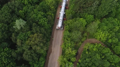 Transporting a large pipe / reactor on a road through a forest on a summer day. Stock Footage 124245347