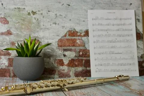 Transverse flute laid on table with sheet music and flower Stock Photos