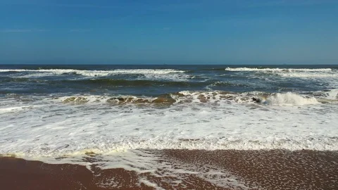Transverse pan along beach with fly out over waves Stock Footage 116775671