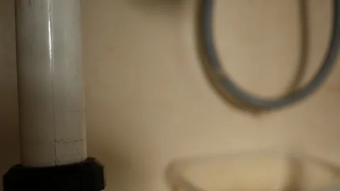 Trap under kitchen sink vanity with leaky hose blurry in background 스톡 동영상 295006859