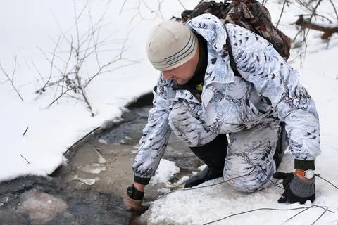 Trapper pulls the trap out of the water Stock Photos