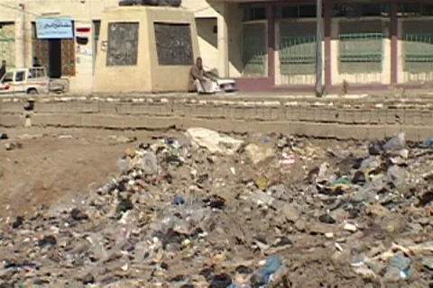 Trash and debris from the Euphrates River, traffic passes in background. Stock Footage 86753731