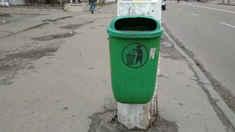 Trash bag in a concrete bin mounted on a pedestrian pavement Stock Footage 121672003
