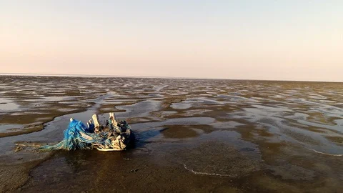 Trash on beach low tide - fly over aerial shot Stock Footage 102841493