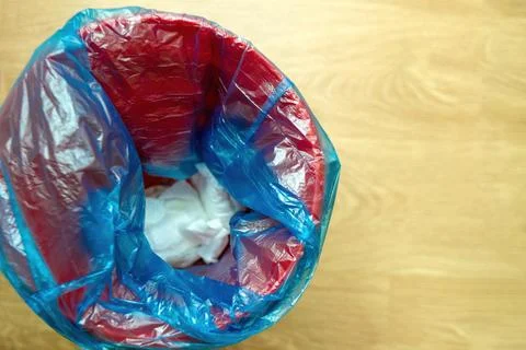 Trash bin filled blue garbage bag containing used diapers, symbolizing waste Stock Photos