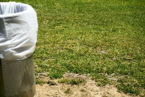 Trash bin in a park with white plastic bag Stock Photos