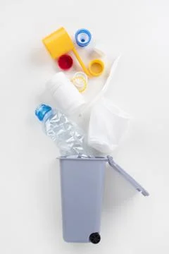 Trash bin with plastic waste on a gray background. Recycling concept Stock Photos
