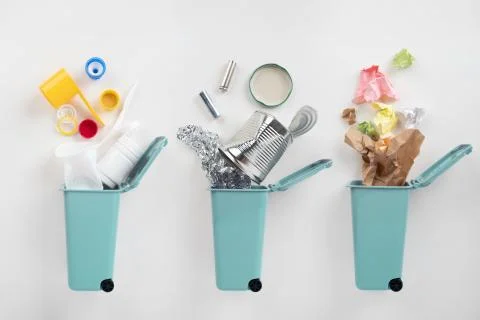 Trash bins and assorted garbage on grey background. Recycle concept Stock-Fotos