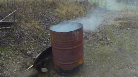 Trash burning in a rusty smoking barrel Stock Footage 33714150