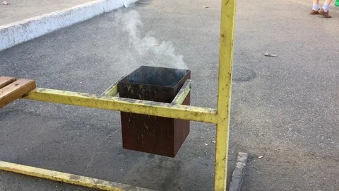 Trash can with garbage burning on the bus station Stock Footage 117156039