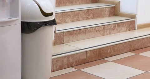 Trash can lid wobbles after trash has been removed near the steps in the int Stock Footage 332409744