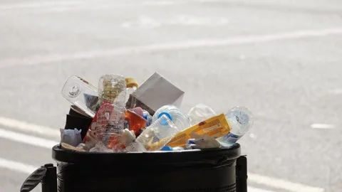A Trash Can Overflowing with Waste Positioned in an Unpleasant Manner by the Stock Footage 281021254