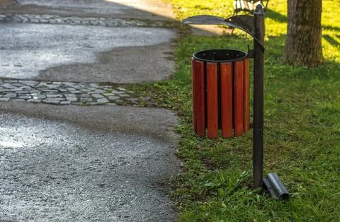A trash can in a park Stock Photos